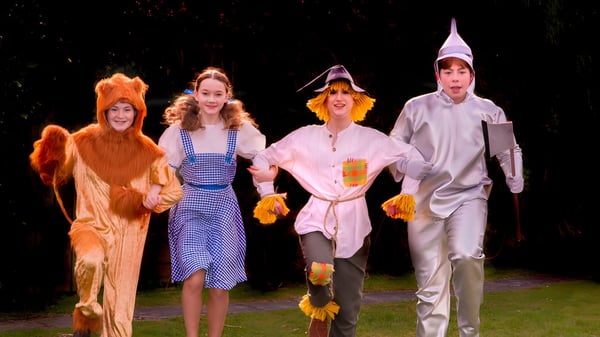 Vier Schülerinnen und Schüler der Read School gehen in bunten Kostümen bei Nacht unter einem sternenklaren Himmel.