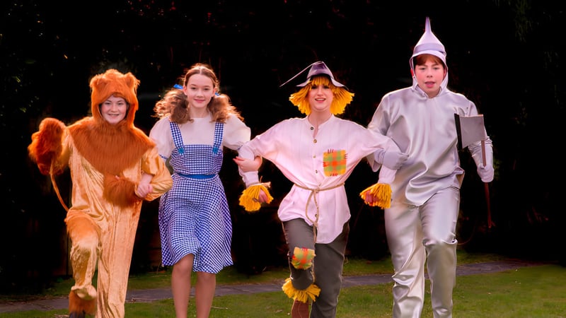 Vier Schülerinnen und Schüler der Read School gehen in bunten Kostümen bei Nacht unter einem sternenklaren Himmel.