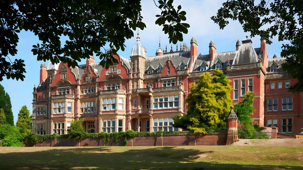 Das eindrucksvolle Gebäude der Reddam House Berkshire zeigt gotische Architektur und ist von gepflegtem Grün umgeben.