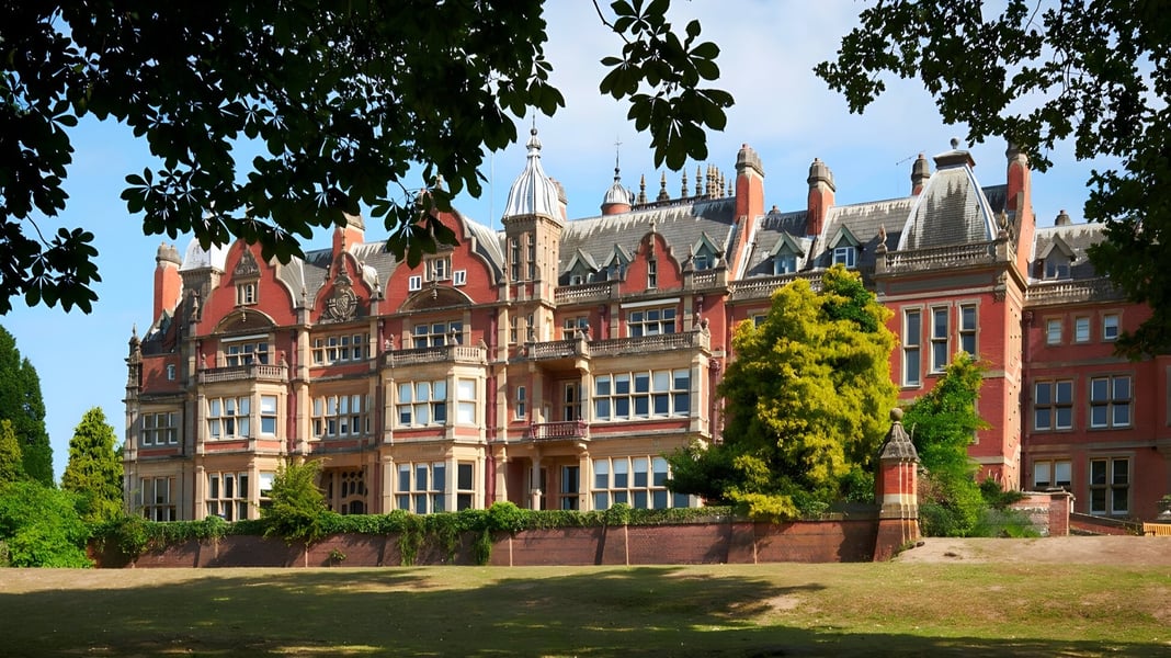 Das eindrucksvolle Gebäude der Reddam House Berkshire zeigt gotische Architektur und ist von gepflegtem Grün umgeben.