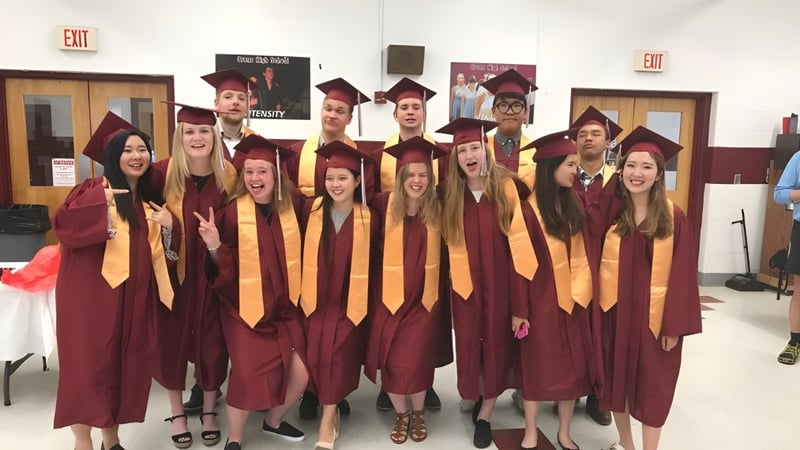 Eine Gruppe von Absolventen in regional School Unit N26 steht gemeinsam in einem Flur mit einem Ausgangsschild im Hintergrund.