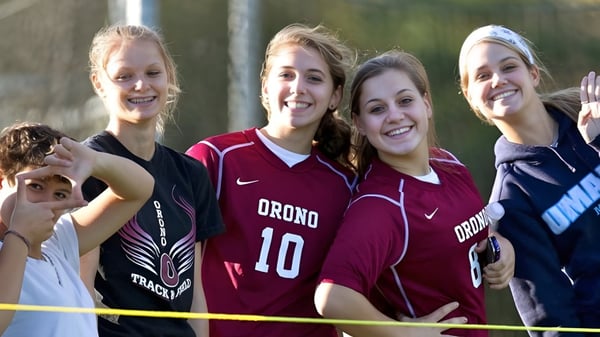 Eine Gruppe Schülerinnen in Sportuniformen posiert im Freien auf dem Gelände der Regional School Unit N26.