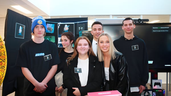 Eine Gruppe Schülerinnen und Schüler der Renmark High School stehen in einem Gaming- und Technikraum mit verschiedenen Bildschirmen und Geräten.