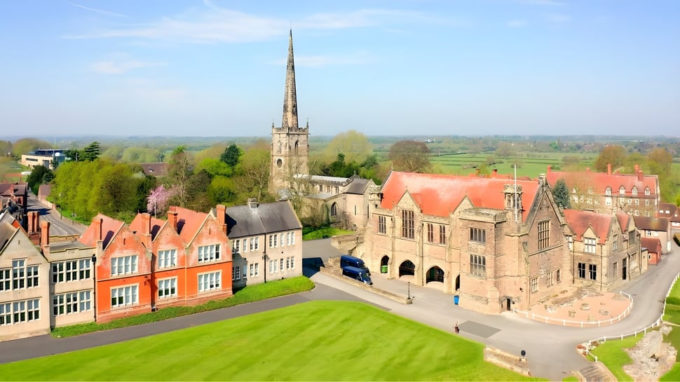 Blick auf eine mittelalterliche Stadt mit bunten Gebäuden und einer hohen Spitze in der Nähe der Repton School.