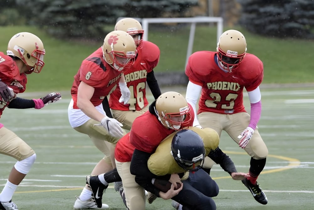 Schüler der Resurrection Catholic School spielen Fußball auf einem Rasenplatz mit Torpfosten im Hintergrund.