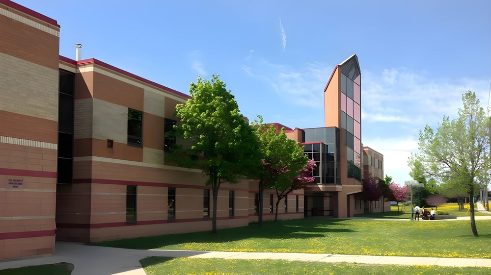 Das moderne mehrstöckige Gebäude der Resurrection Catholic School steht eingebettet in eine grüne Landschaft mit Bäumen und Rasen.