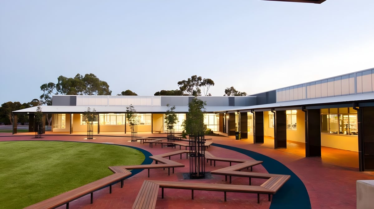 Das moderne Gebäude des Reynella East College ist einstöckig und von gepflegten Grünflächen sowie einem gepflasterten Weg umgeben.