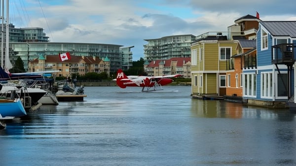 Bunte Wasseransicht mit schwimmenden Häusern und Booten vor modernen Hochhäusern nahe der Reynolds Secondary School.