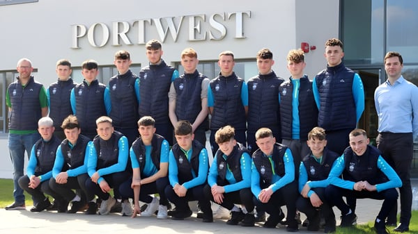 Eine Gruppe von Personen in einheitlicher Kleidung steht vor dem Gebäude des Rice College mit dem Schild Port West.