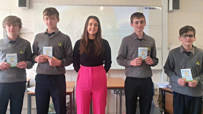 Eine Gruppe von Schülern des Rice College steht in einem Klassenzimmer mit einem Whiteboard im Hintergrund.