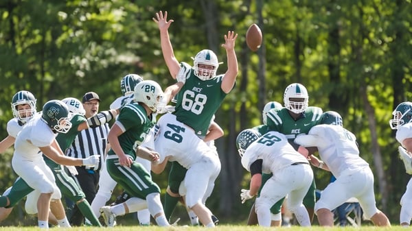 Eine Gruppe von Fußballspielern in grünen und weißen Uniformen spielt auf dem Spielfeld der Rice Memorial High School.