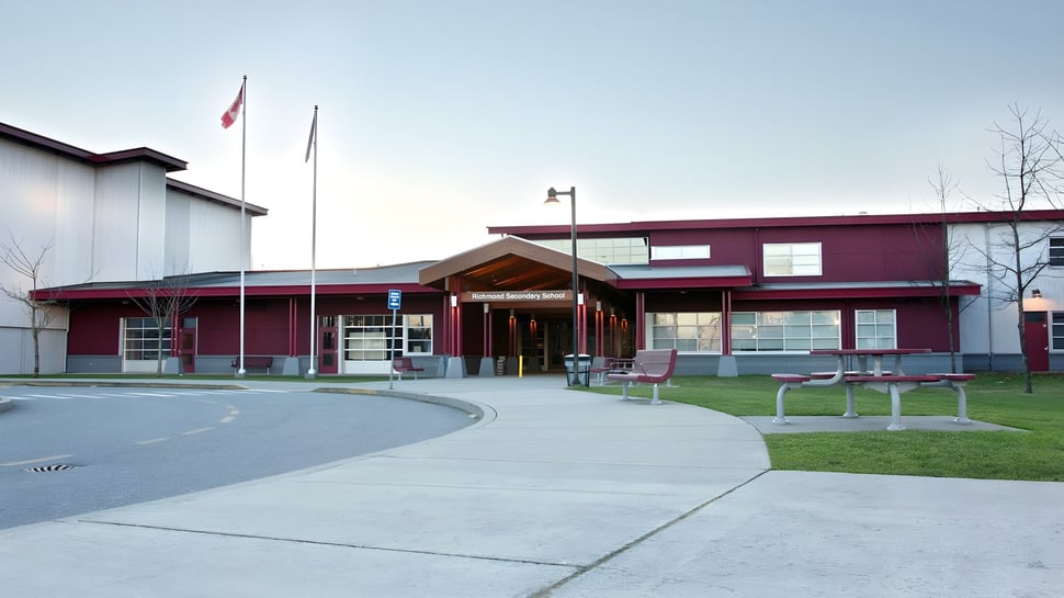 Das moderne mehrstöckige Schulgebäude der Richmond Secondary School mit kanadischer Flagge außerhalb.