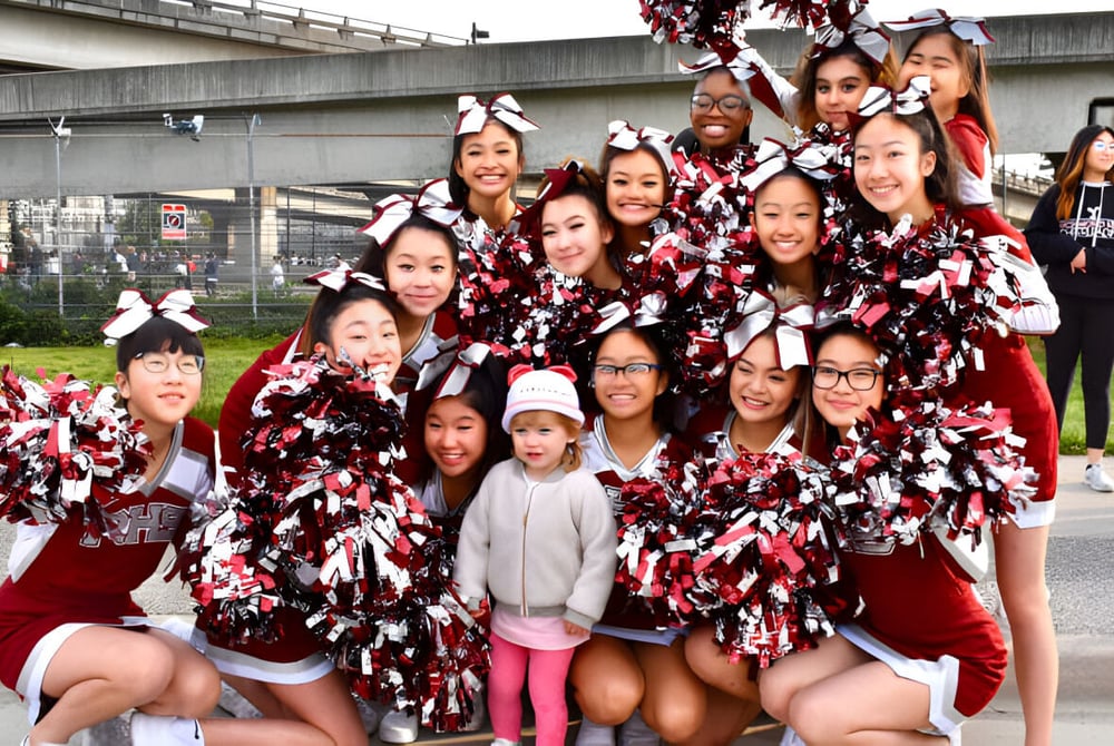 Eine Gruppe von Cheerleadern in Rot-Weiß posiert draußen auf dem Gelände der Richmond Secondary School.