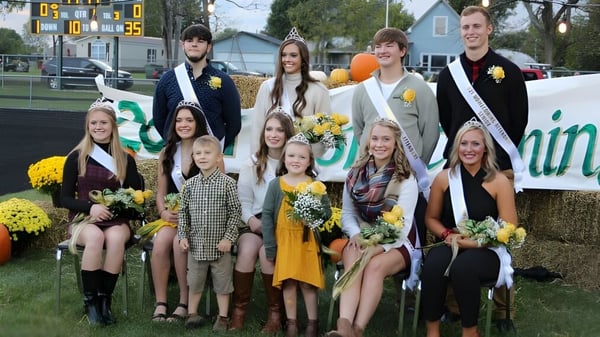 Eine Gruppe von Schülerinnen und Schülern der Ridgemont High School steht vor einem Sportstadion mit Blumen in der Hand.