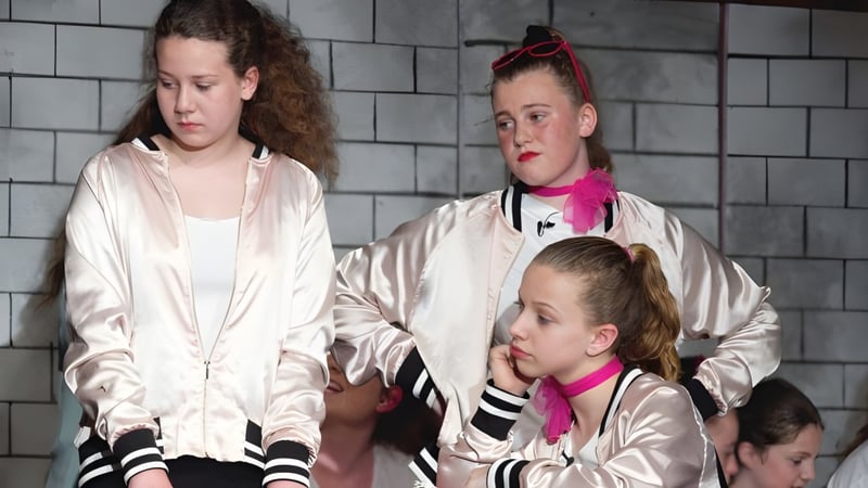 Drei Schülerinnen der Ridgetown District High School stehen vor einer grauen Betonwand.