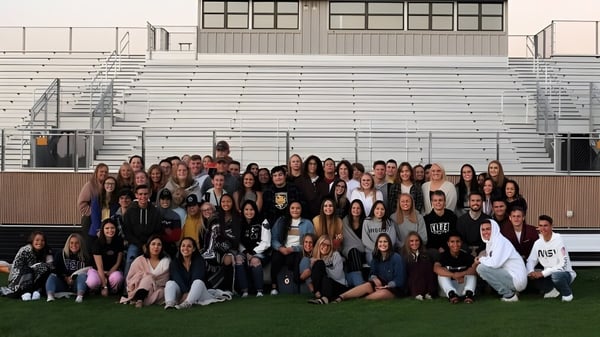 Eine Gruppe von Schülerinnen und Schülern versammelt sich vor einem Gebäude auf dem Campus der Ridgeview High School.
