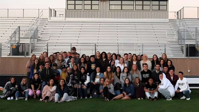 Eine Gruppe von Schülerinnen und Schülern versammelt sich vor einem Gebäude auf dem Campus der Ridgeview High School.