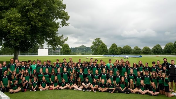 Eine Gruppe von Schülerinnen und Schülern der Ringwood School versammelt sich auf einer Wiese mit Bäumen im Hintergrund.
