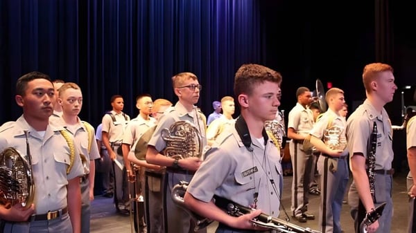 Mitglieder der Riverside Military Academy stehen in Uniform auf einer Bühne vor einem dunklen Vorhang.
