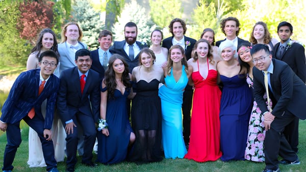 Eine Gruppe von Schülerinnen und Schülern der Riverstone International School steht zusammen in einem grünen Außenbereich.