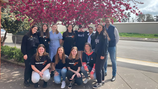 Eine Gruppe junger Frauen steht vor einem blühenden Baum auf dem Gelände der Riverton and District High School.