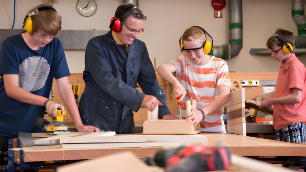 Schüler der Riverview Middle School arbeiten gemeinsam an einem Holzprojekt in der Werkstatt.