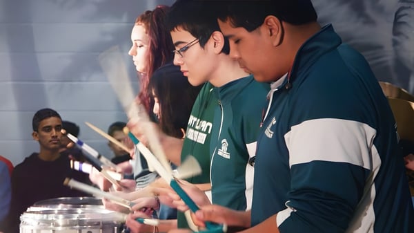 Schüler der Robert Bateman Secondary School führen eine gemeinsame Performance auf einer Bühne auf.