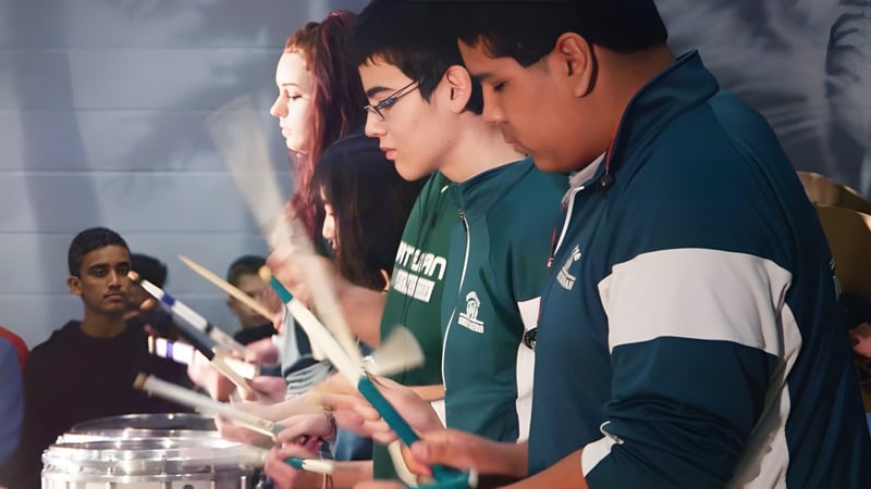 Schüler der Robert Bateman Secondary School führen eine gemeinsame Performance auf einer Bühne auf.