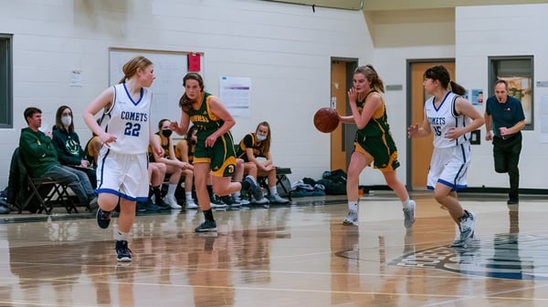Schüler der Robert Thirsk High School spielen ein Basketballspiel in der Sporthalle.