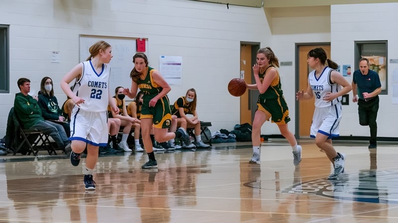 Schüler der Robert Thirsk High School spielen ein Basketballspiel in der Sporthalle.