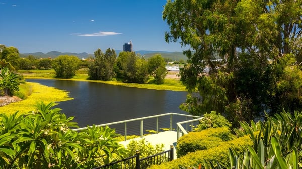 Eine ruhige Flusslandschaft mit hohen Bäumen und klarem Himmel in der Nähe der Robina State High School.