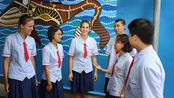 Eine Gruppe von Schülerinnen und Schülern der Rochedale State High School steht vor einem bunten Wandbild mit abstrakten Mustern.