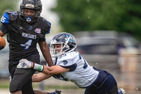 Zwei Football-Spieler der Rockford Lutheran School kämpfen auf dem Spielfeld um den Ball.