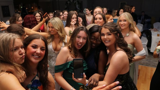 Schülerinnen der Rockford Manor School gruppieren sich und machen ein gemeinsames Foto mit einem Smartphone.