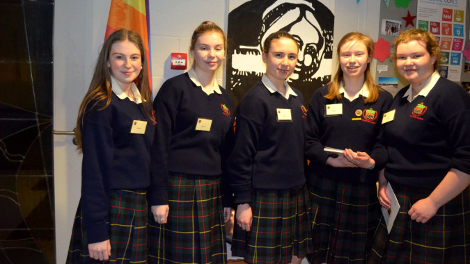 Eine Gruppe Schülerinnen der Rockford Manor School steht vor einem bunten Wandbild.