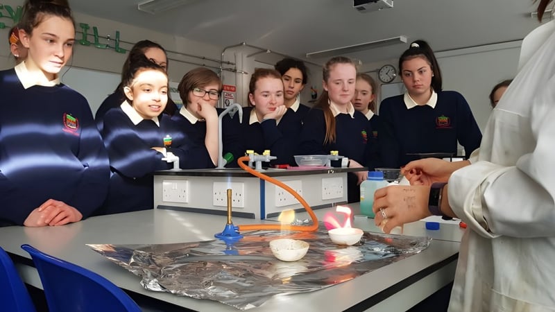 Schüler der Rockford Manor School beobachten gemeinsam ein Experiment mit Laborgeräten am Unterrichtstisch.