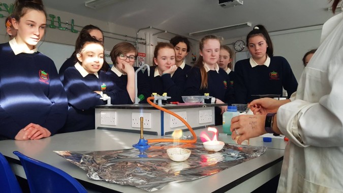 Schüler der Rockford Manor School beobachten gemeinsam ein Wissenschaftsexperiment mit verschiedenen Labormaterialien.