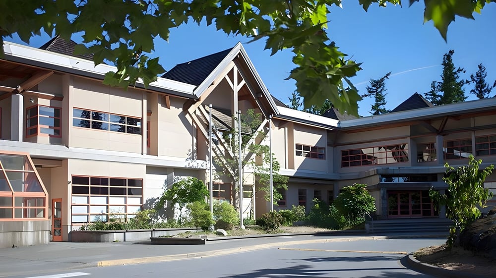 Das moderne mehrstöckige Gebäude der Rockridge Secondary School ist von üppigem Grün und blauem Himmel umgeben.