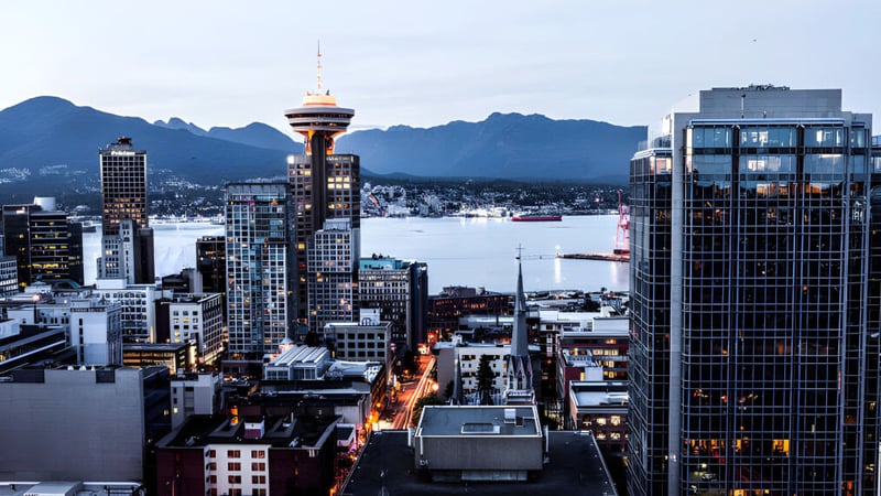 Blick auf die lebhafte Stadtsilhouette mit Wolkenkratzern und einem Kommunikationsturm hinter dem Campus der Rockridge Secondary School.