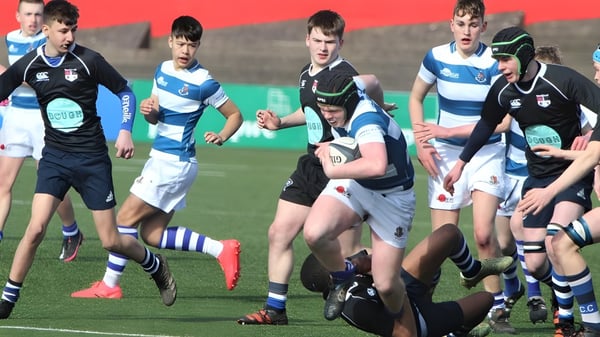 Schüler des Rockwell College spielen ein intensives Rugby-Match auf dem grünen Spielfeld.