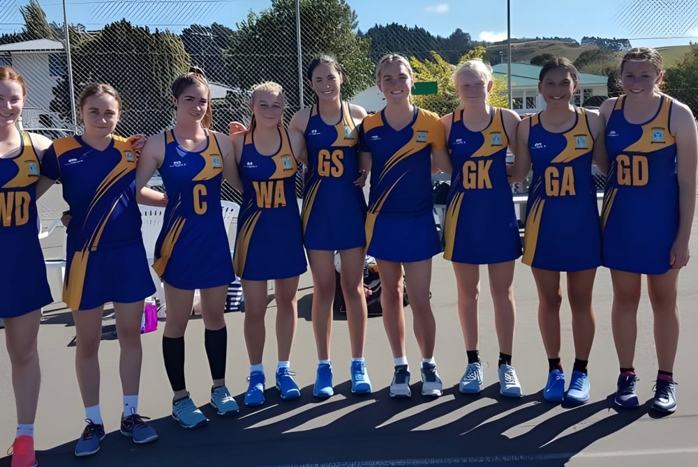 Eine Gruppe junger Netballspielerinnen steht auf dem Spielfeld auf dem Campus des Roncalli College.