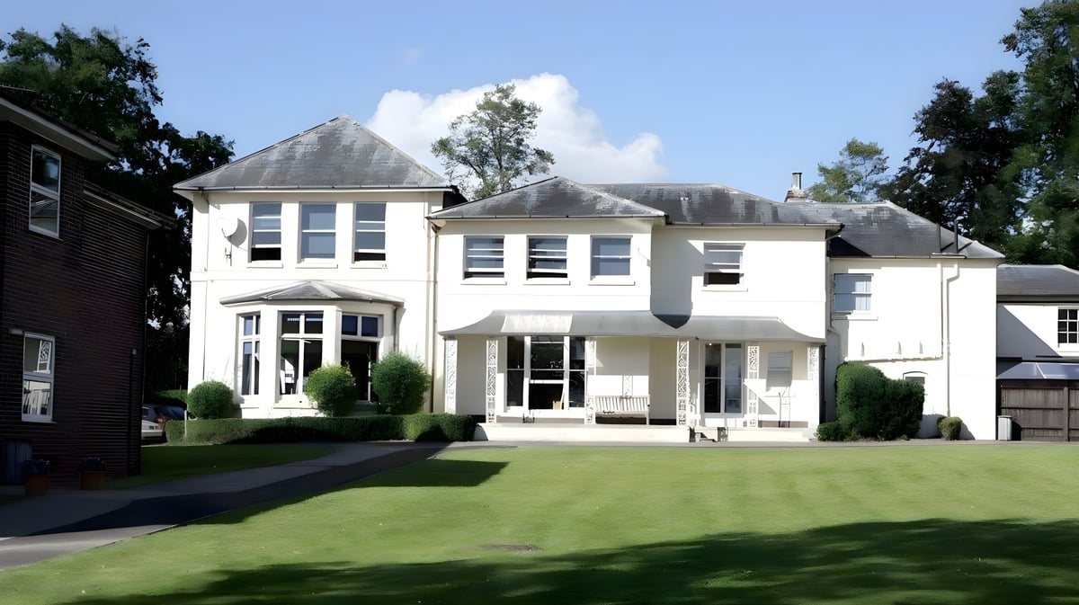 Das weiße mehrstöckige Hauptgebäude der Rookwood School steht auf einem gepflegten Rasen und ist von Bäumen umgeben.