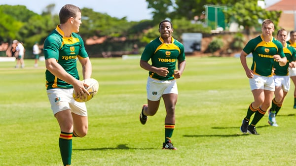 Eine Gruppe von Rugby-Spielern läuft auf dem Sportplatz der Rose Bay High School.