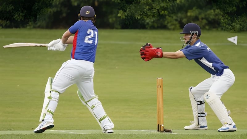 Zwei Cricket-Spieler in blauen Uniformen spielen ein Match auf dem Spielfeld des Rosmini College.