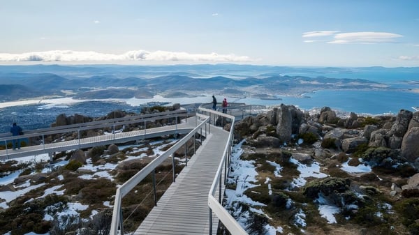 Schüler des Rosny College wandern auf einem Holzweg durch eine schneebedeckte Berglandschaft zu einem Aussichtspunkt.