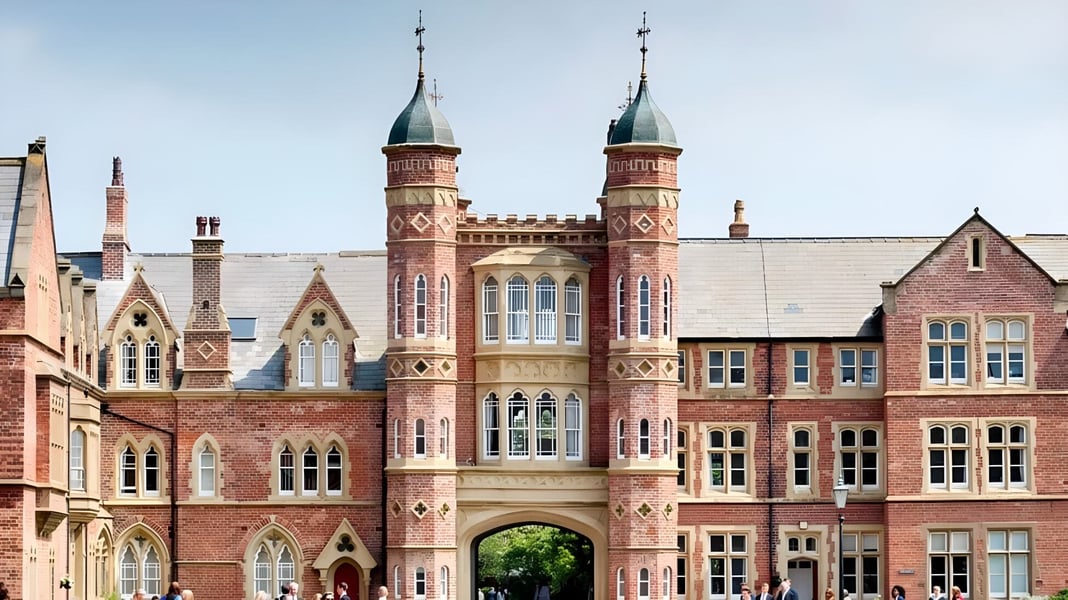 Das historische Hauptgebäude der Rossall School mit zwei Türmen im europäischen Stadtbild.