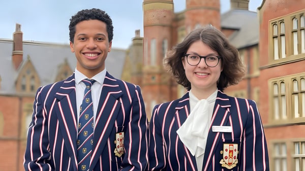 Zwei Schülerinnen der Rossall School stehen vor einem historischen Backsteingebäude.