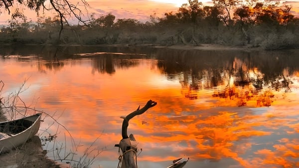 Ein ruhiger See mit herbstlichem Sonnenuntergang und umgebender Vegetation auf dem Gelände der Roxby Downs Area School.