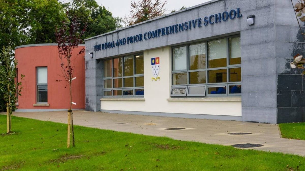 Das moderne mehrstöckige Schulgebäude der Royal and Prior Comprehensive School mit großen Fenstern und einer Rasenfläche im Vordergrund.