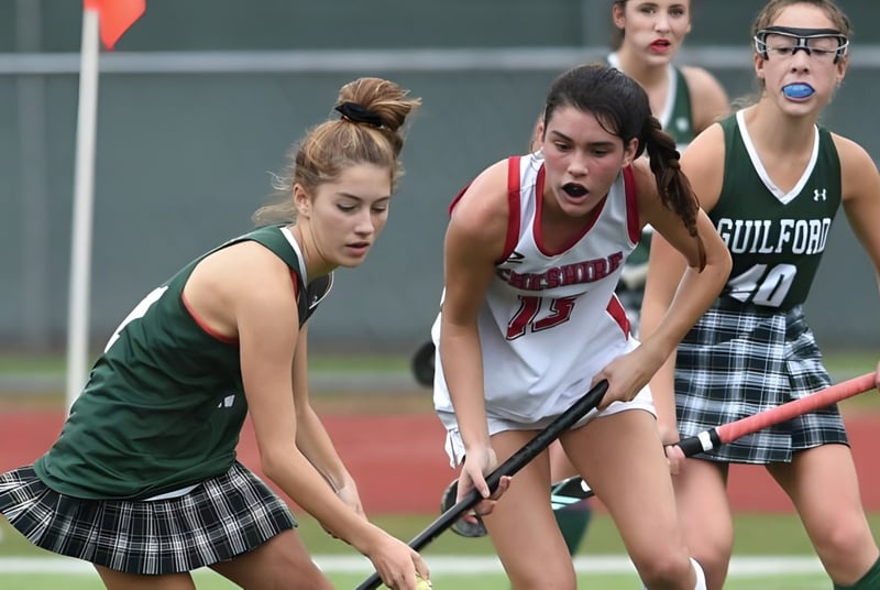 Eine Gruppe von Athletinnen beim Wettkampf auf dem Sportplatz der Royal Masonic School for Girls.